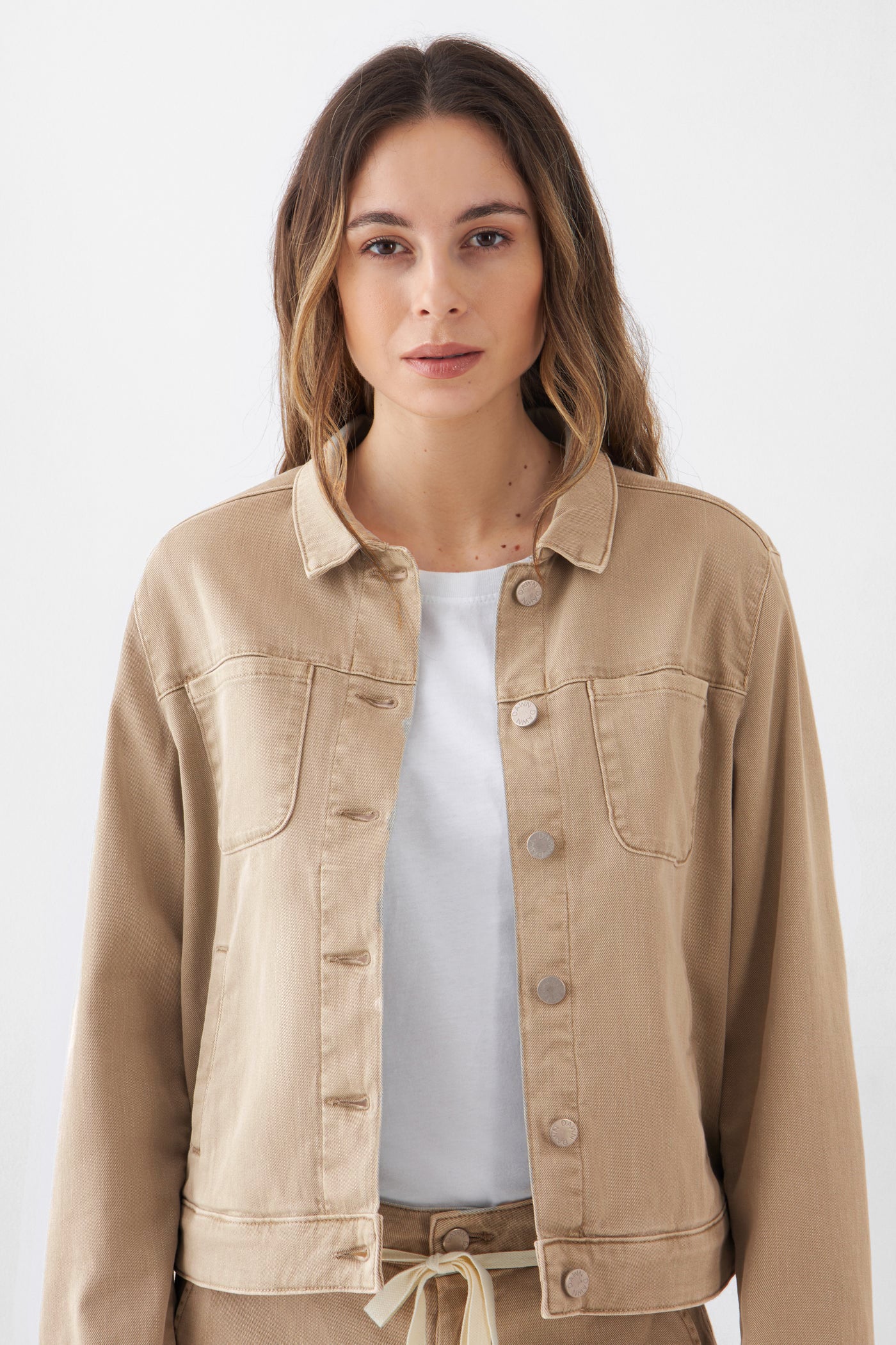 CALLISTO Jeansjacke aus Organic Soft Denim in Warm Sand, klassischer gerader Schnitt, Brusttaschen und Knopfleiste vorn; getragen über einem weißen Shirt.
