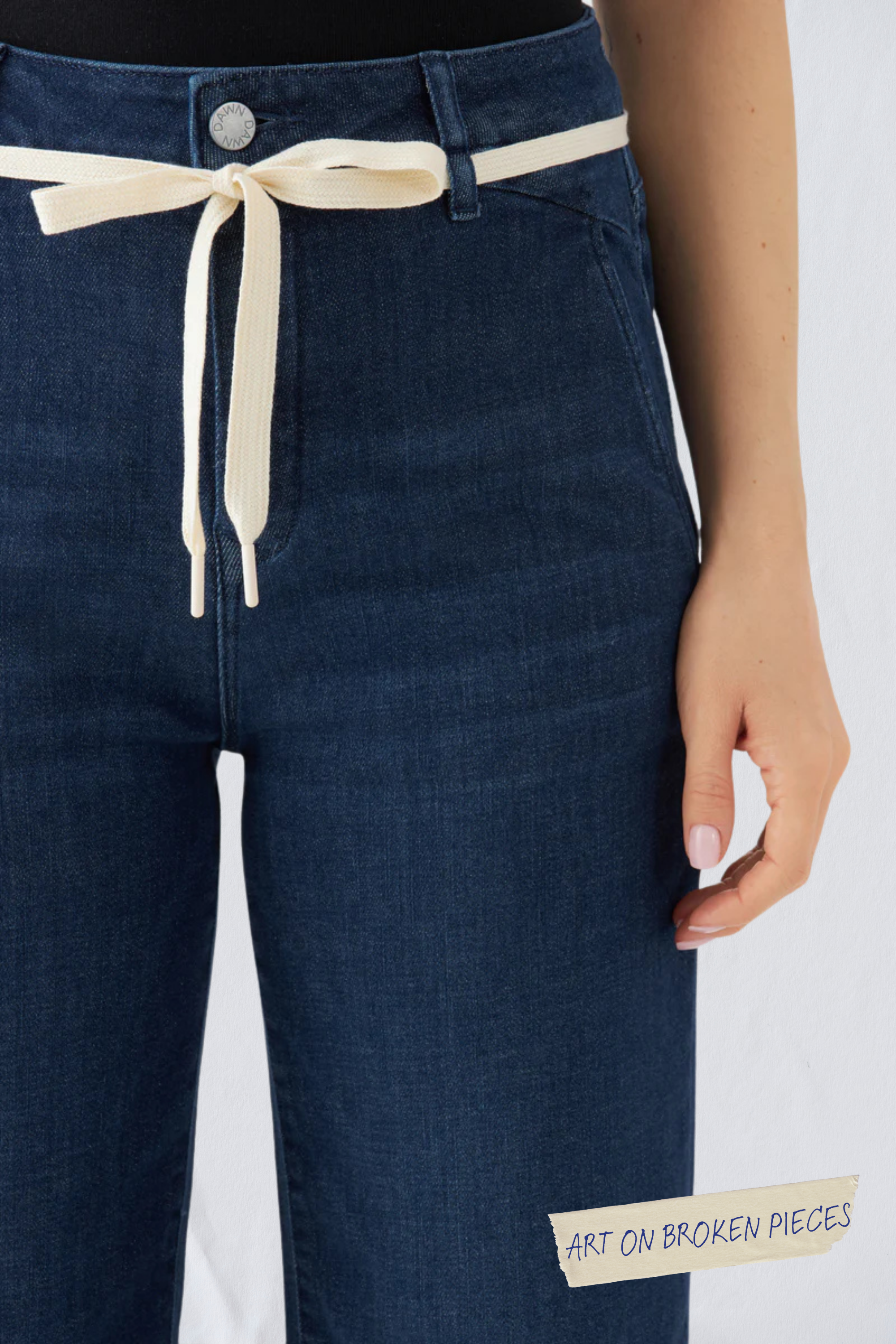 DEW Cropped French Pocket Jeans, Dunkelblau, hohes Bund, ausgestelltes Bein, cremefarbenes Bindegürtelband; Vorderansicht.