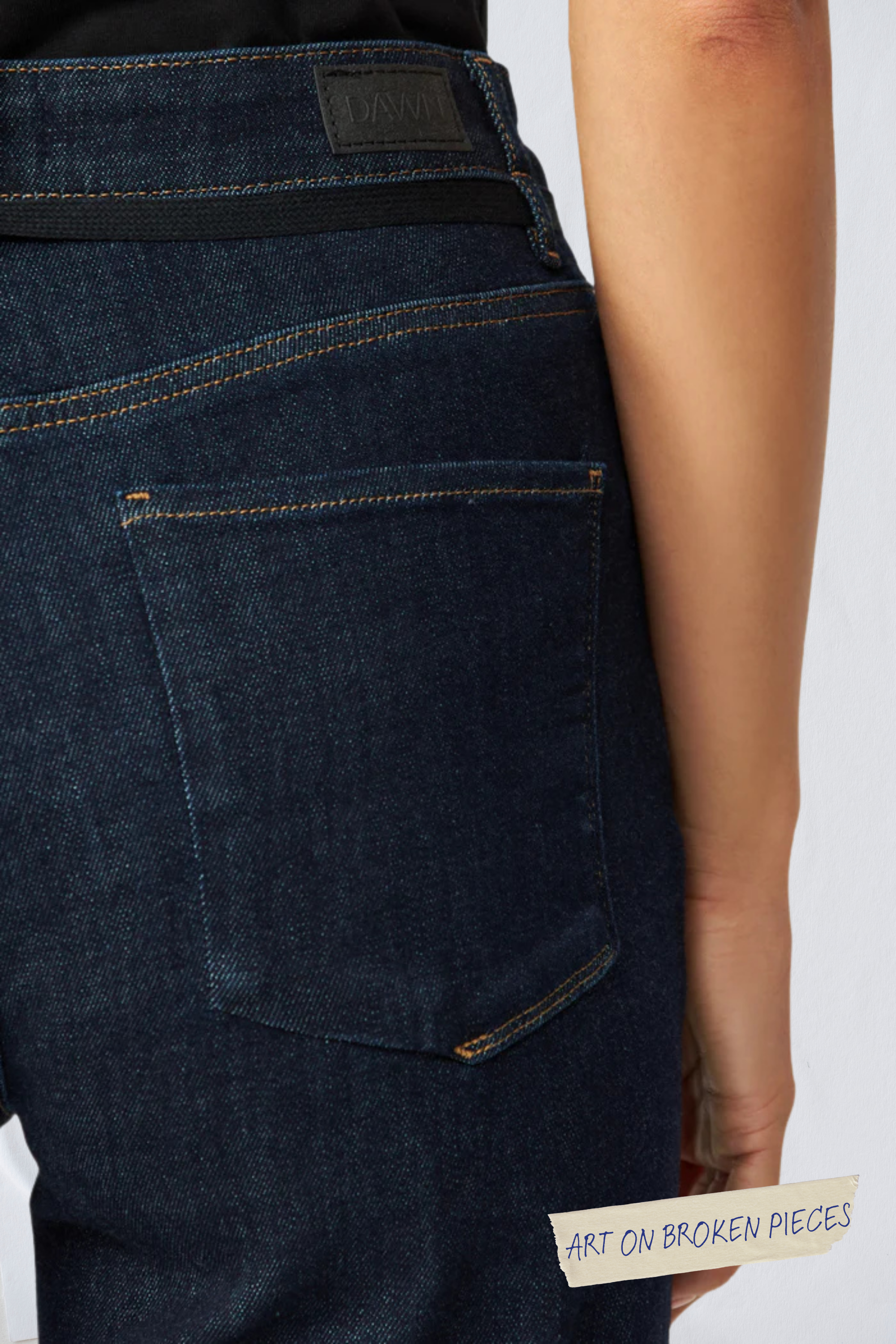 Rückansicht der Raw Blue DEW Jeans mit Gesäßtasche, orange Kontrastnähte, DAWN-Label am Bund – Art on Broken Pieces.