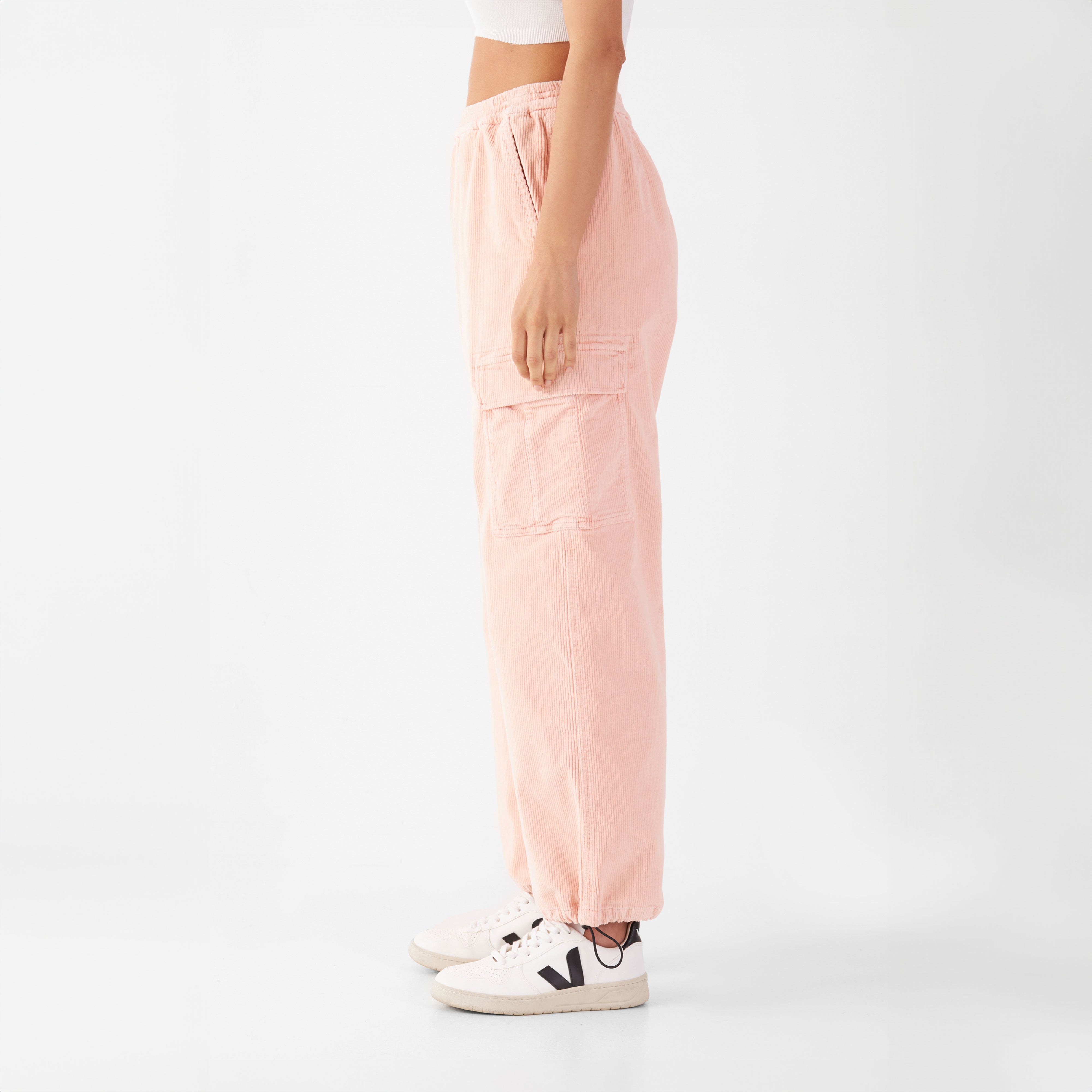 Seitliche Ansicht der rosa Cordhose RAY: entspannte Passform, Cargo-Taschen, elastischer Bund, verstellbares Knöchelband.