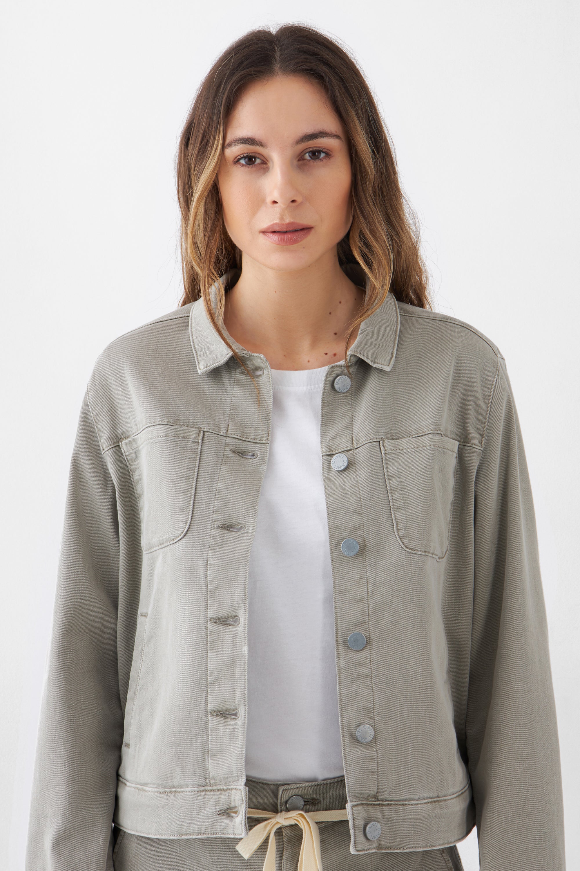 CALLISTO Soft Organic Jeansjacke in Rock Olive, klassischer gerader Schnitt, zwei Brusttaschen, Frontknopfverschluss – getragen von einer Frau mit weißem Shirt.