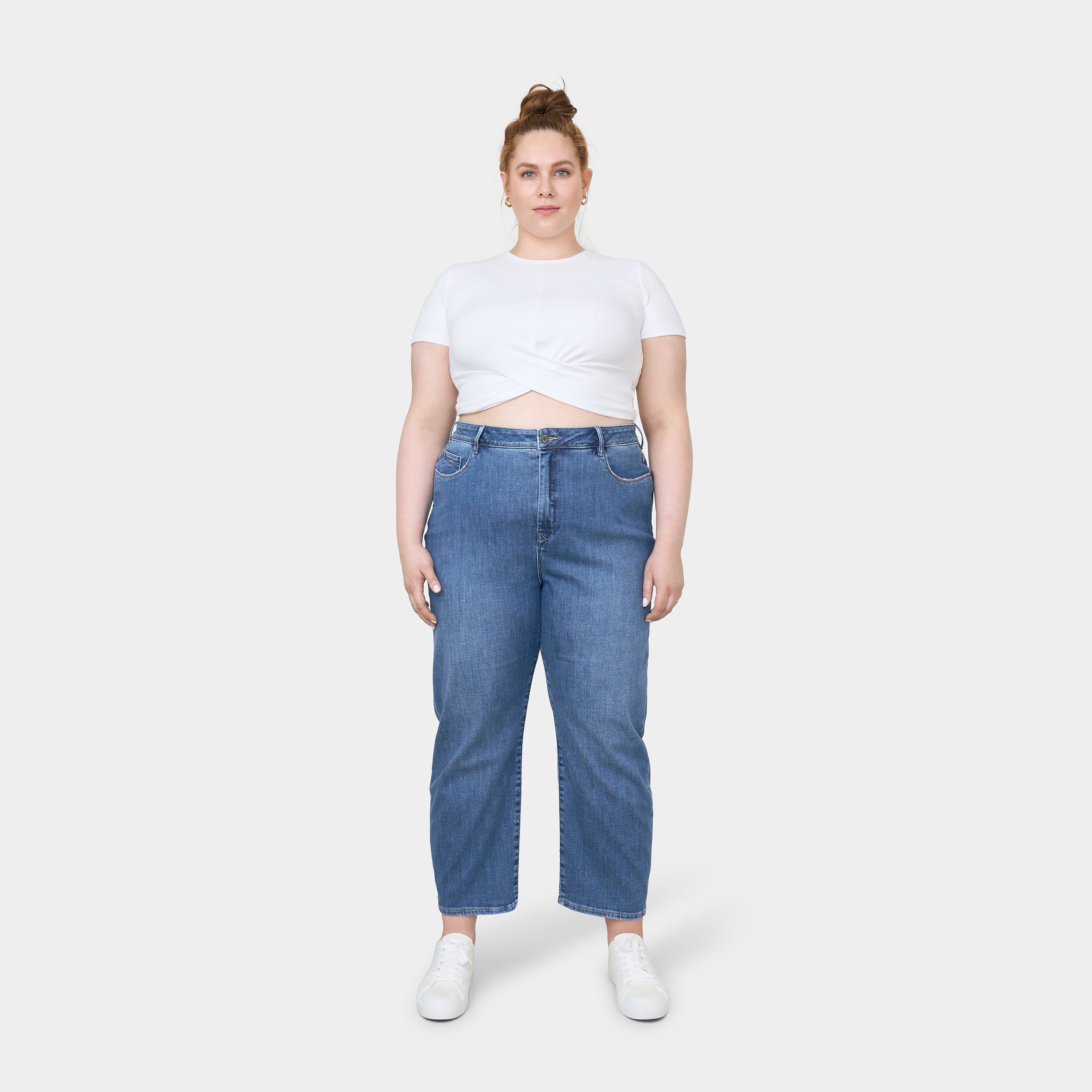 STARDUST O-Shape Jeans in Medium Blue, hoch tailliert und entspannt in der Hüfte, mittellanger Beinverlauf, Saum wird schmal (O-Shape); Model trägt weißes Crop-Top.