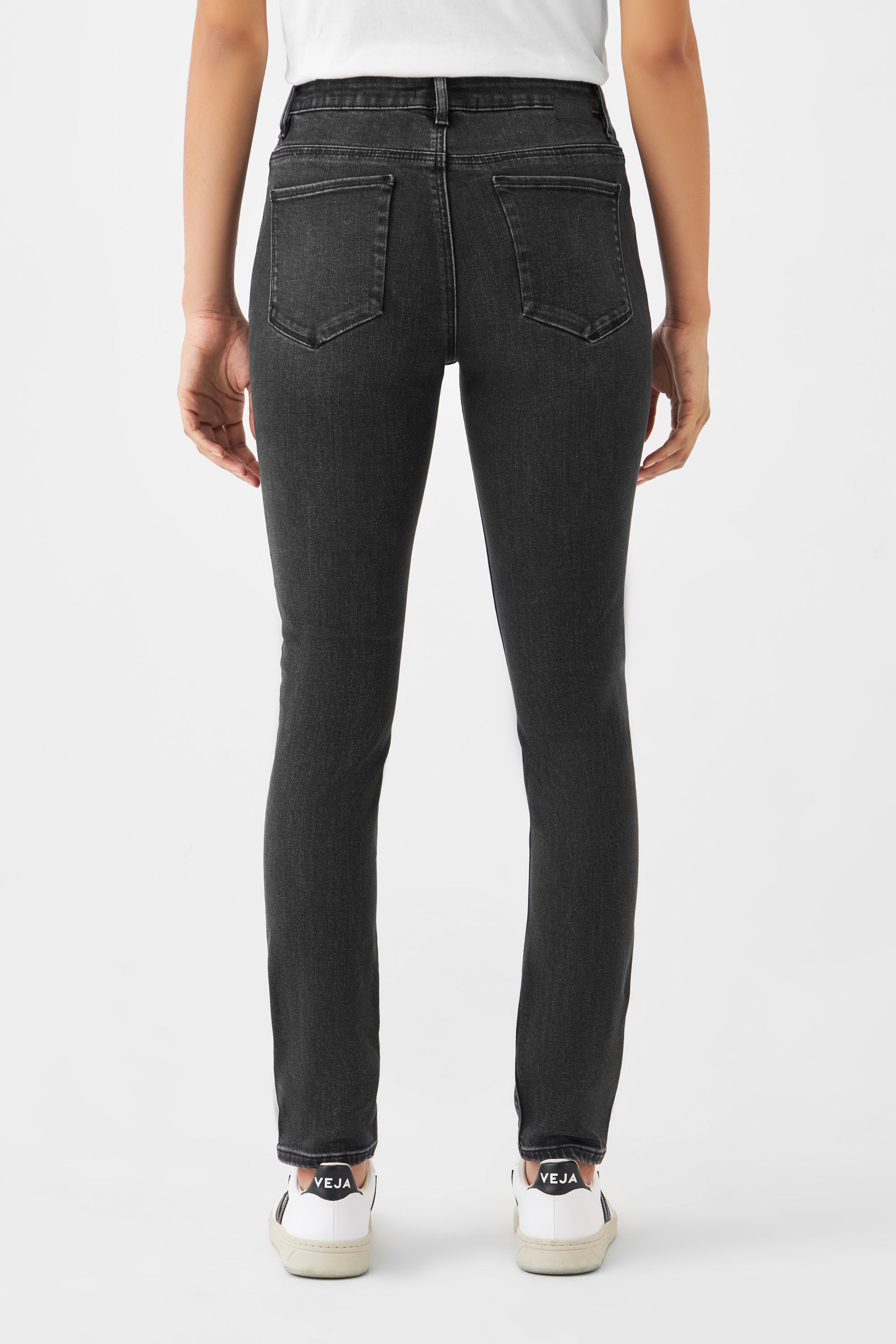 SUN UP Basic Skinny Jeans in Black Denim, mittelhoher Bund, Powerstretch-Formung; Rückenansicht mit zwei Gesäßtaschen, getragen zu weißen VEJA-Sneakern.