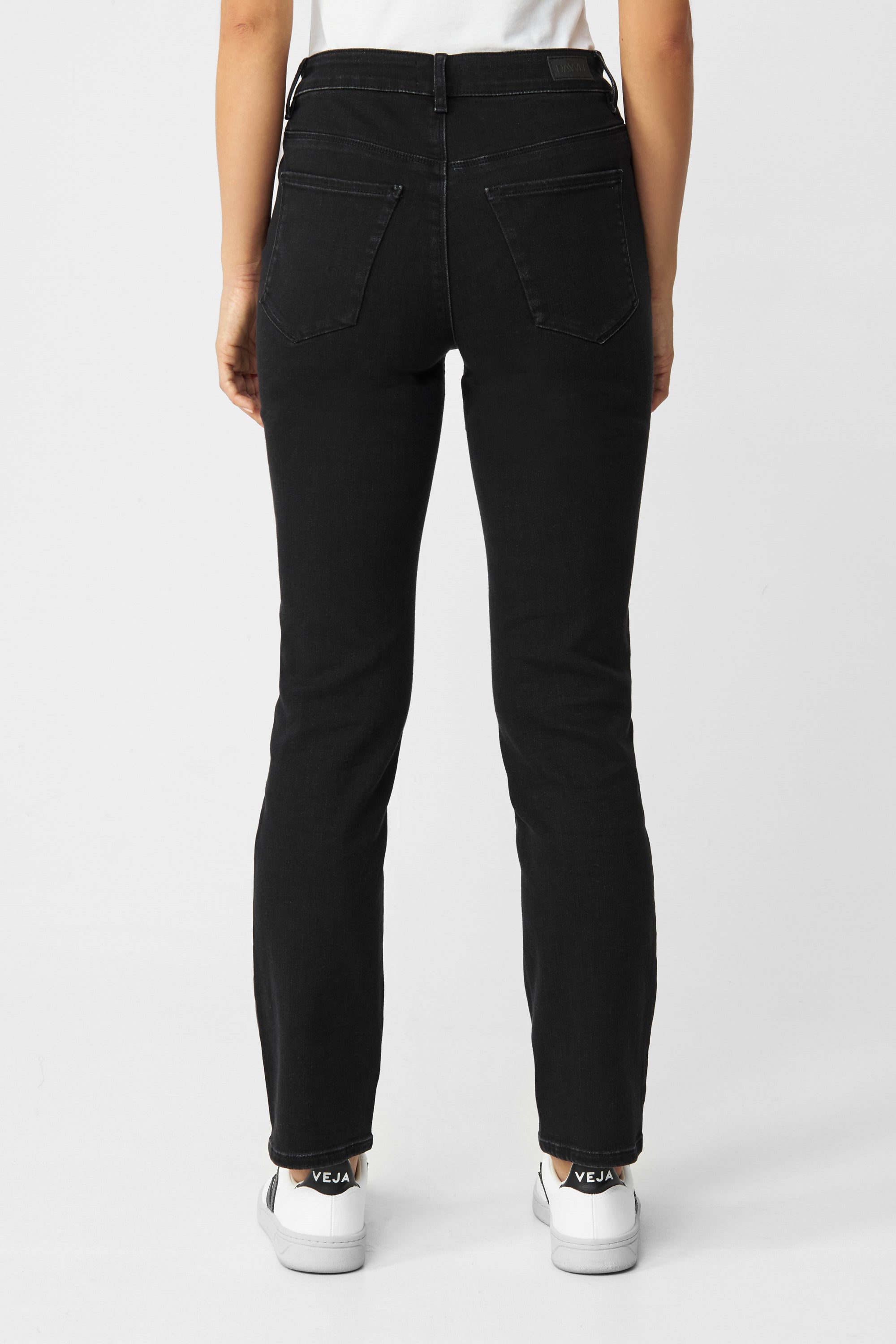 Rückansicht einer schwarzen STELLAR Slim Comfortstretch Jeans von DAWN – High-Waist, schmaler Beinverlauf, 5-Pocket-Design, aus Bio-Baumwolle.