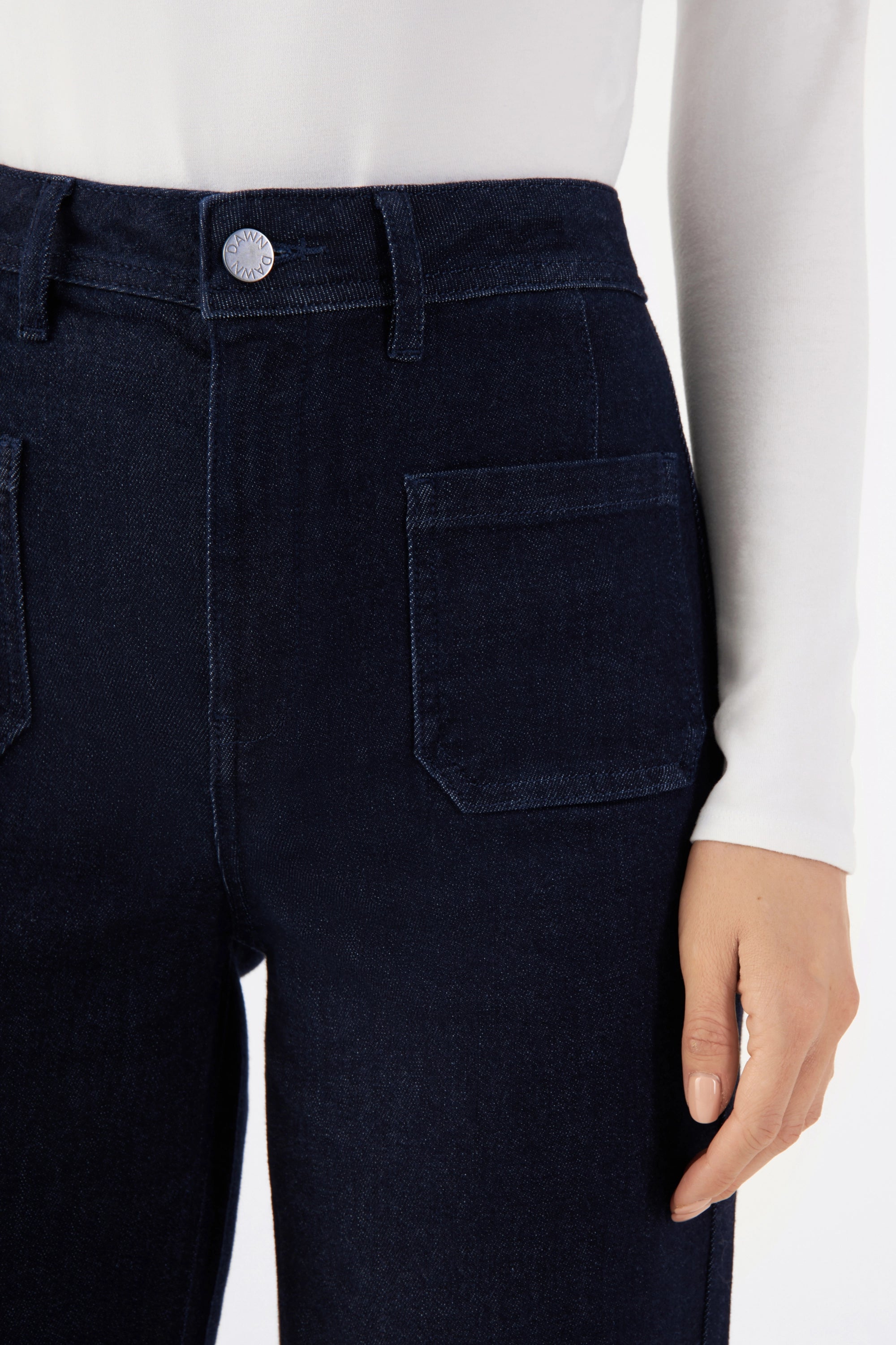DEW Sailor Raw Blue – hoch taillierte, flare Jeans aus Organic Soft Denim; Nahaufnahme des Bundes mit Knopf, Gürtel-Schlaufen und einer Rückentasche.
