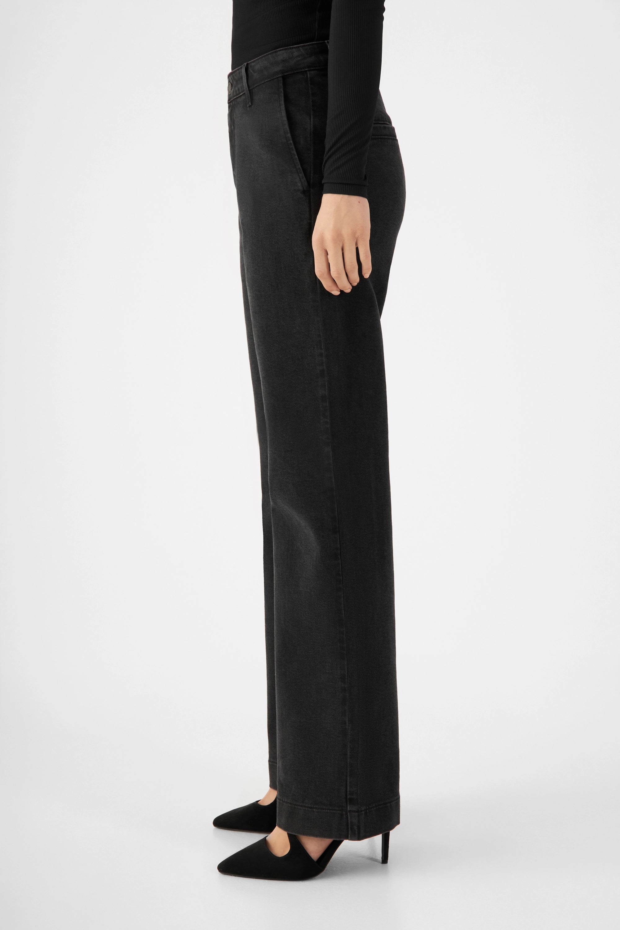 GLOW Flared Soft Tencel Denim-Chino Vintage Black, mittelhoher Taille, weites Bein; Seitenansicht, schwarze Pumps.