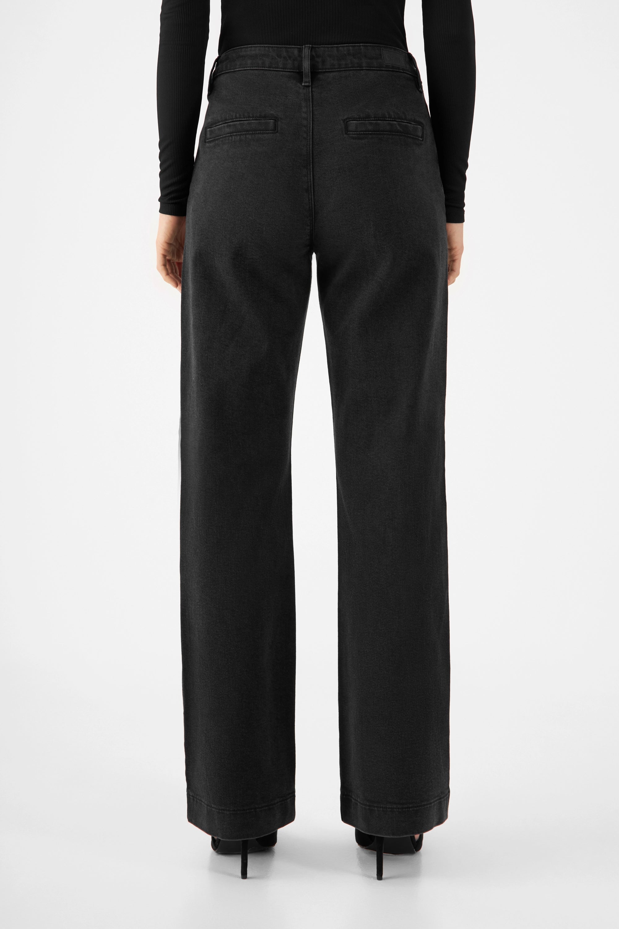 GLOW Vintage Black Denim-Chinos, mittelhohe Taille, Rückansicht mit zwei Paspeltaschen hinten und ausgestelltem Bein.